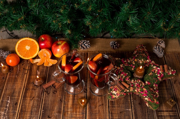 Weihnachtsglühwein mit Früchten und Gewürzen auf Holztisch