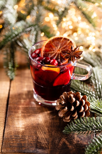 Weihnachtsglühwein mit Gewürzen auf einem hölzernen rustikalen Tisch