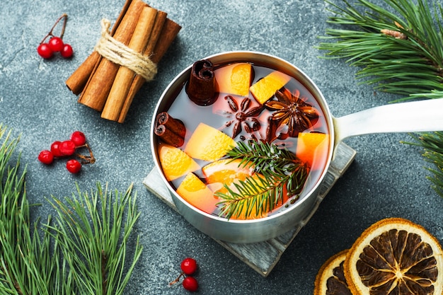 Weihnachtsglühwein mit Gewürzen und Frucht auf dem Tisch. Neues jahr-konzept