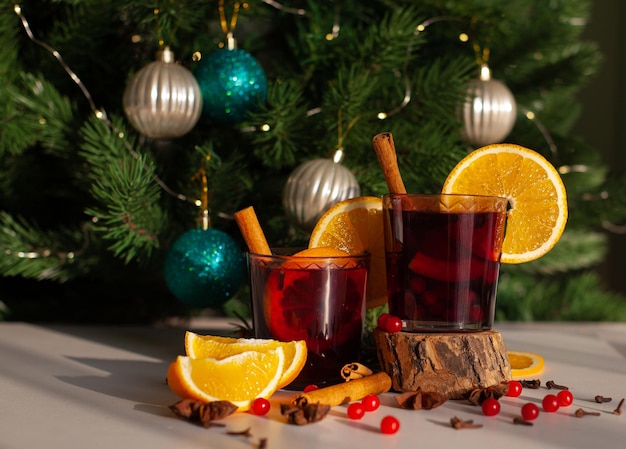 Weihnachtsglühwein mit Zimtstange, Orange, Anis und Nelken mit Schatten aus Sonnenlicht auf weißem Hintergrund. Winterferien.