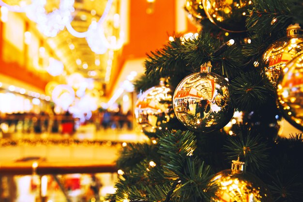 Weihnachtsgoldkugeln hängen an einem Weihnachtsbaum