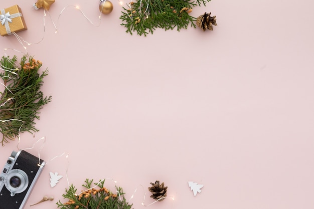 Weihnachtsgrenze. Weihnachtsrahmen mit Geschenken, Tannenzweigen auf pastellrosa Hintergrund. Flache Lage, Ansicht von oben, Kopienraum