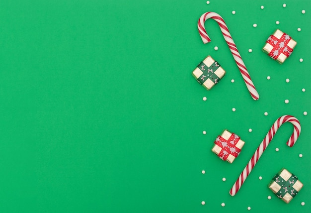 Weihnachtsgrün mit zwei Zuckerstangen, Geschenkboxen mit rotem und grünem Band und Perlen.