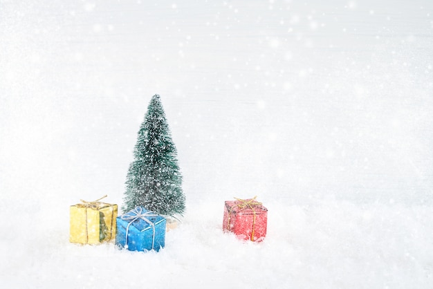 Weihnachtsgrußkarte. Dekorativer Weihnachtstannenbaum mit Geschenken herum, Schnee. Platz kopieren