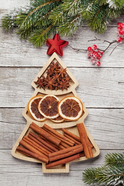 Weihnachtsgrußkarte mit Gewürzen in einer Fichte-förmigen Schachtel Anise trockene Orange und Zimt Top-View Flat Lay