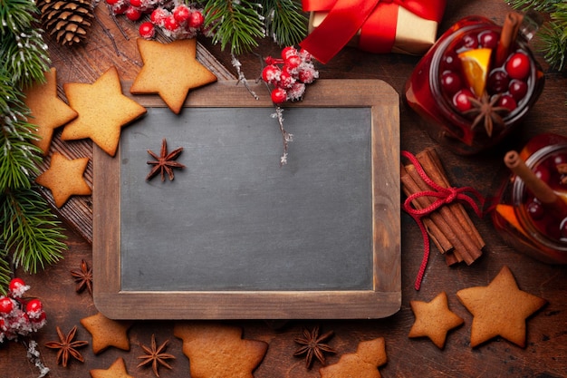 Weihnachtsgrußkarte mit Glühwein-Lebkuchenplätzchen und Weihnachtsbaum Draufsicht flach liegend mit Tafel für Ihre Grüße