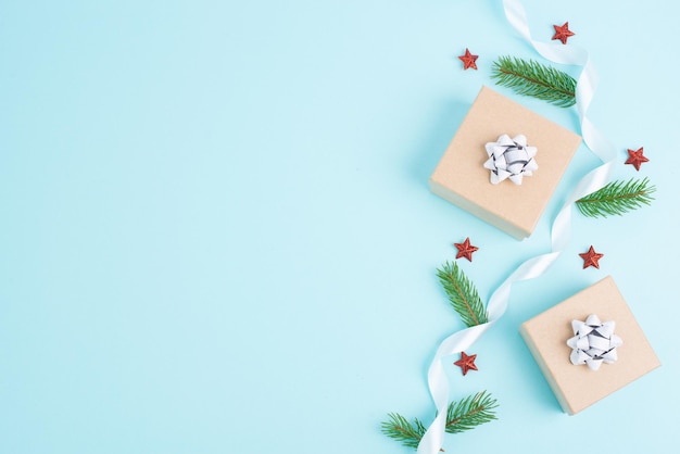 Weihnachtsgrußkarte mit kleinen Geschenkkisten, Sternen und Tannenzweigen auf blauem Hintergrund