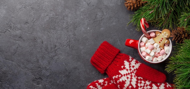 Weihnachtsgrußkarte mit Tannenbaum und Kakao-Tasse mit Marshmallow-Süßigkeiten und Lebkuchen-Mann Auf Steinhintergrund mit Kopierplatz für Ihre Weihnachtsgrußwünsche