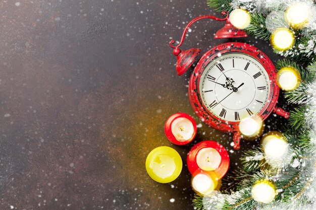 Foto weihnachtsgrußkarte weihnachtshintergrund mit schnee tannenbaum kerzen und wecker blick von oben mit platz für ihre grüße