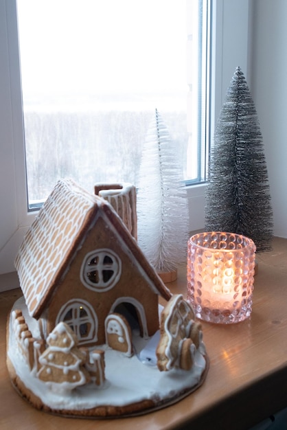 Foto weihnachtshaus aus lebkuchen mit lebkuchenauto außen in weihnachtsstimmung dekoriert