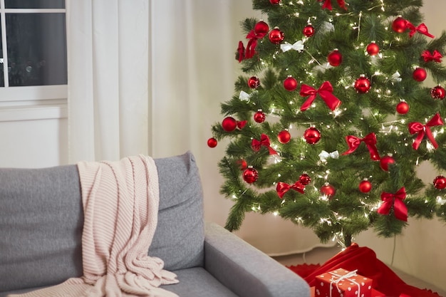Weihnachtshaus stilvolles Wohnzimmer mit Weihnachtsbaumsofa und Geschenkboxen mit Geschenken