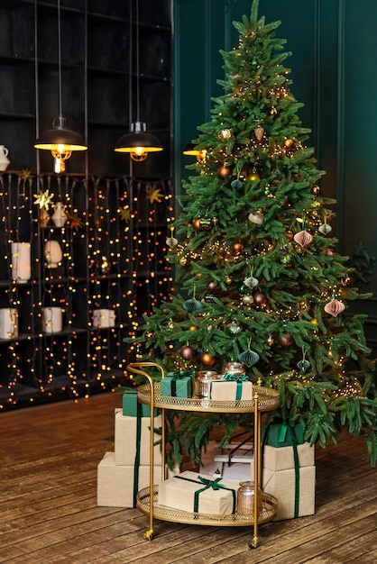 Weihnachtsheimzimmer mit Tannenbaum und festlicher Bokeh-Beleuchtung verschwommener Feiertagshintergrund Geschenkboxen und Neujahrsdekor Weicher selektiver Fokus