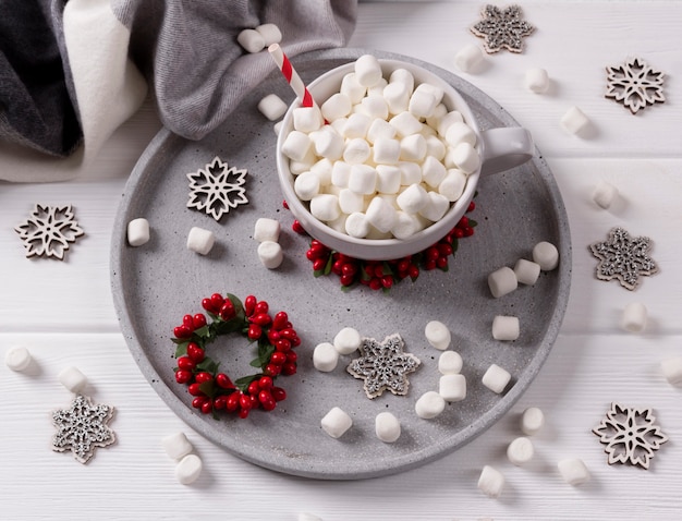 Weihnachtsheiße Schokolade oder -kaffee mit Eibisch auf weißem Holztisch mit Weihnachtsdekorationen