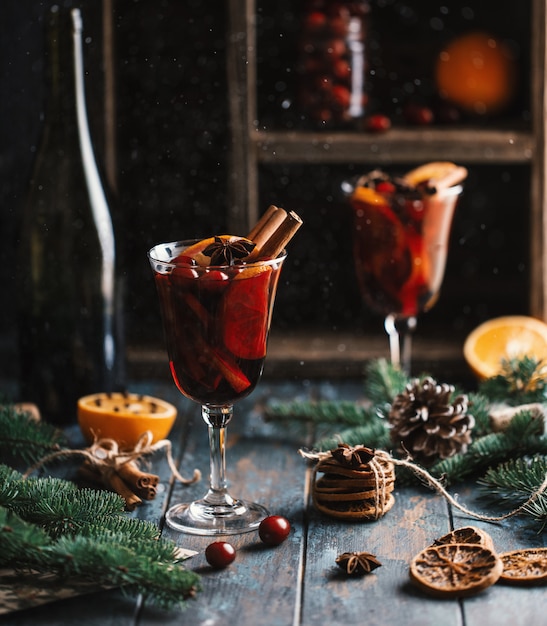 Weihnachtsheißer Glühwein in einem Glas mit Gewürzen, Zitrusfrüchten und Moosbeeren.