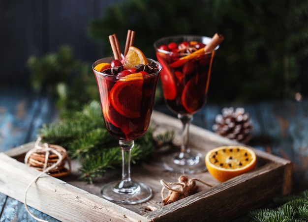 Weihnachtsheißer glühwein in einem glas mit gewürzen, zitrusfrüchten und moosbeeren.