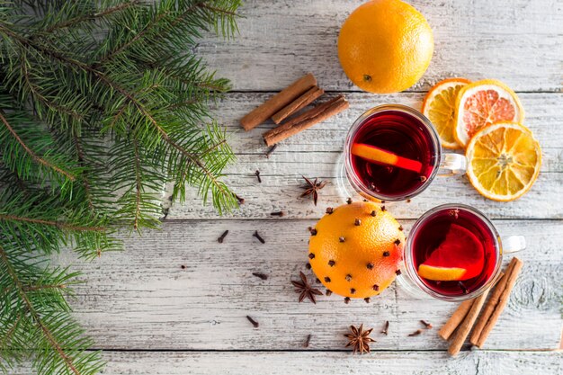 Weihnachtsheißer Glühwein mit Zimtorange und -anis auf weißem hölzernem Hintergrund