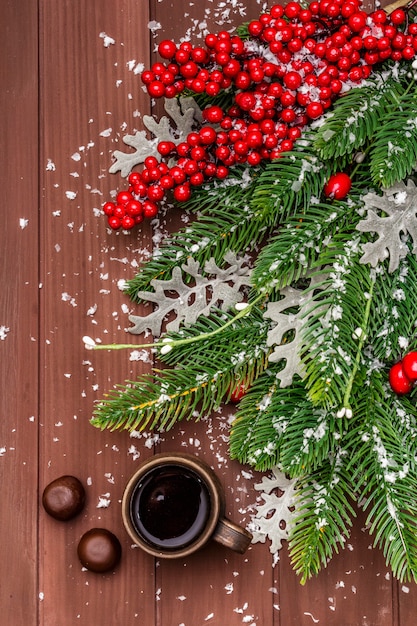 Weihnachtsheißer Kaffee, Tannenbaum, frische Blätter, Pralinen und künstlicher Schnee.