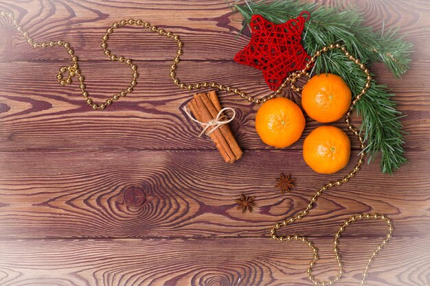 Weihnachtshintergrund - antikes Holz, Tannenzweige, Tannenzapfen, Kerzen und Mandarinen, Neujahrsdekor. Flache Lage, leerer Raum.
