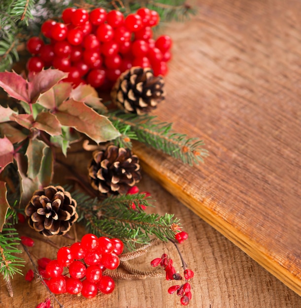 Weihnachtshintergrund aus Ipadoub-Fichtenzweigen Zapfen rote Viburnum-Beeren auf dunklem rustikalem Holzhintergrund Weihnachtshintergrund Kopieren Sie Platz für die Draufsicht des Textes