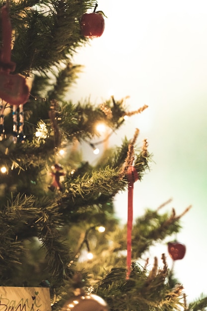 Weihnachtshintergrund eines schönen verzierten Baums mit Lichtern und glänzenden Kugeln