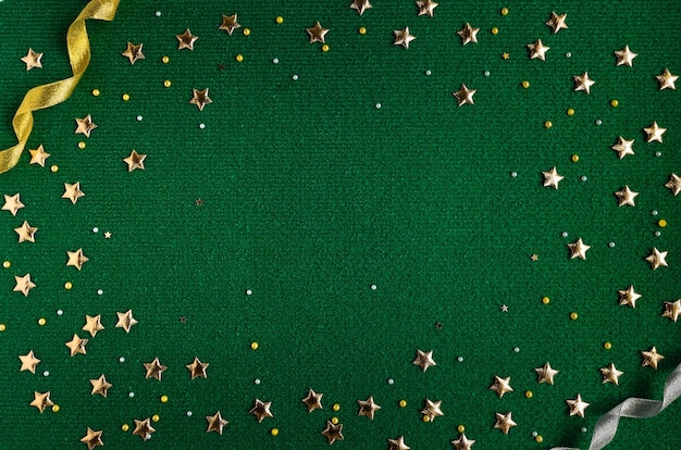 Weihnachtshintergrund in dunkelgrüner Farbe mit Glitzer- und Goldsternen und Bändern in der Form