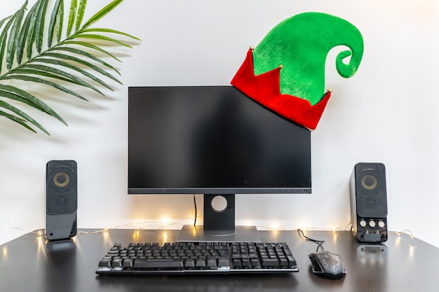 Weihnachtshintergrund mit Computereinrichtung mit Hut und Kopienraum für Text