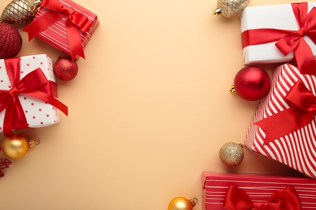 Weihnachtshintergrund mit Dekorationen und Geschenkboxen auf beige Hintergrund. Ansicht von oben