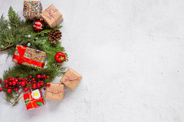 Weihnachtshintergrund mit Dekorationen und Geschenkboxen auf hölzernem Brett.