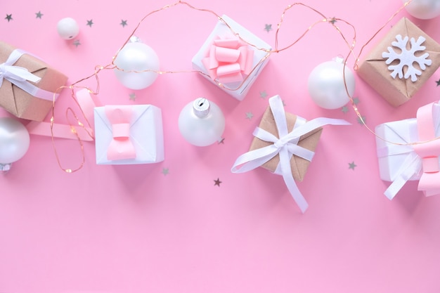 Weihnachtshintergrund mit Dekorationen und Geschenkboxen auf Rosa