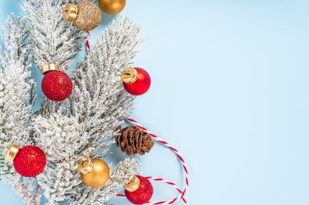 Weihnachtshintergrund mit einem verzierten Weihnachtsbaumast auf einem hellblauen