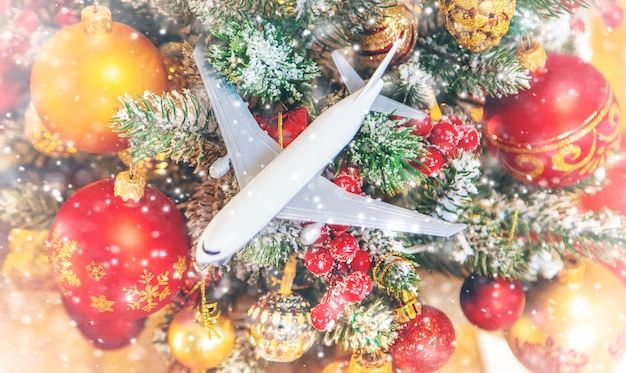 Weihnachtshintergrund mit Flugzeug. Reisekonzept für die Feiertage. Selektiver Fokus. Neujahr.