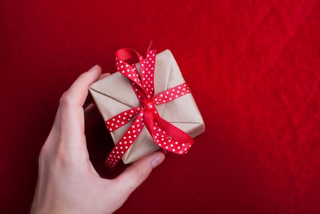 Weihnachtshintergrund mit Geschenk auf rotem Hintergrund Karte der frohen Weihnachten