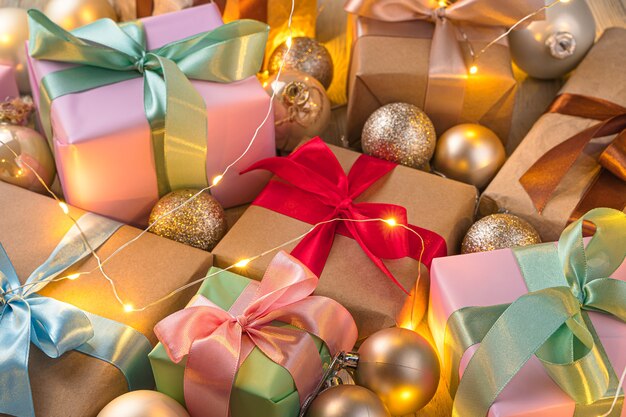 Weihnachtshintergrund mit Geschenken und Weihnachtskugeln im Licht einer Girlande