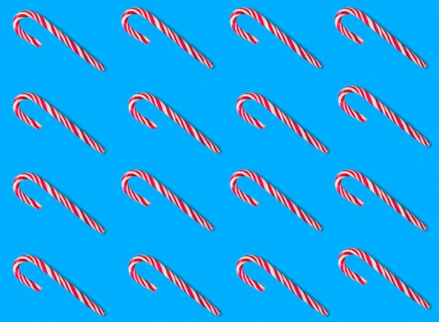 Weihnachtshintergrund mit Karamellrohr auf blauem HintergrundPatternFlat lag