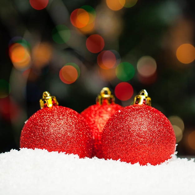 Weihnachtshintergrund mit roten Kugeln und abstraktem Bokeh-Licht