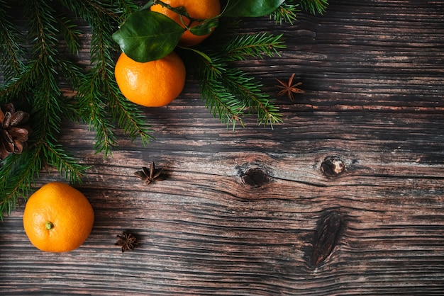 Weihnachtshintergrund mit Tangerinen, Tannenzweigen und Sternanis