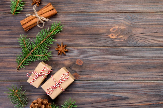 Weihnachtshintergrund mit Tannenbaum und Geschenkbox auf Holztisch. Draufsicht mit Exemplar