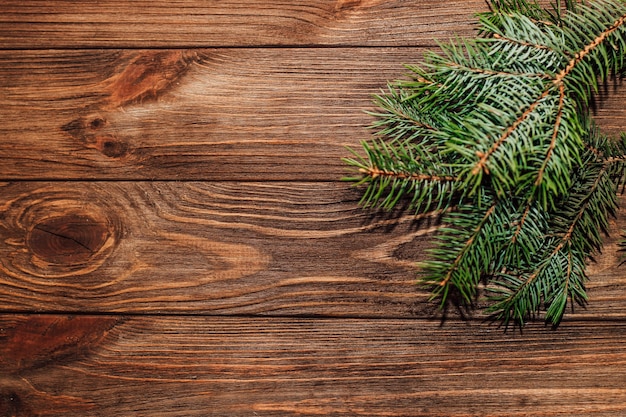 Weihnachtshintergrund mit Tannenzweig auf Holzbrettern.