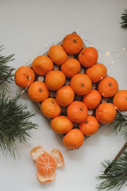 Weihnachtshintergrund mit Tannenzweigen und Mandarinen Frohe Weihnachten und guten Rutsch ins neue Jahr...