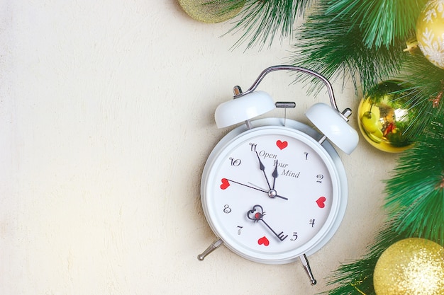 Weihnachtshintergrund mit weißer roter Uhr, goldene Christbaumkugeln