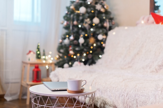 Weihnachtshintergrund oder Grußkarte mit Laptop und Kaffeetasse zu Hause