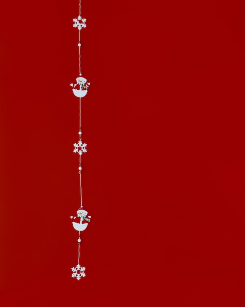 Weihnachtshintergrund. Schneemänner und Schneeflocken auf rotem Grund. Platz für Text. Neujahrskarte.