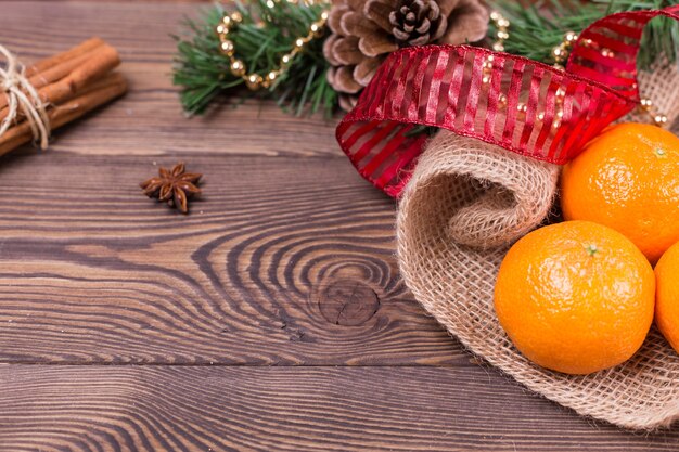 Weihnachtshintergrund - Vintage-Holz, Zimt, Sternanis, süße Mandarinen, ein Neujahrsdekor. Draufsicht, Leerzeichen