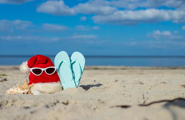 Foto weihnachtshintergrund weihnachtsmann-hut am strand