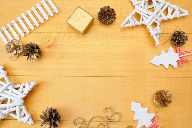 Weihnachtshintergrundkraftpapierblatt papier mit Platz für Ihren Text und weißen Weihnachtsbaumstern und -kegel auf einem Goldhölzernen Hintergrund.