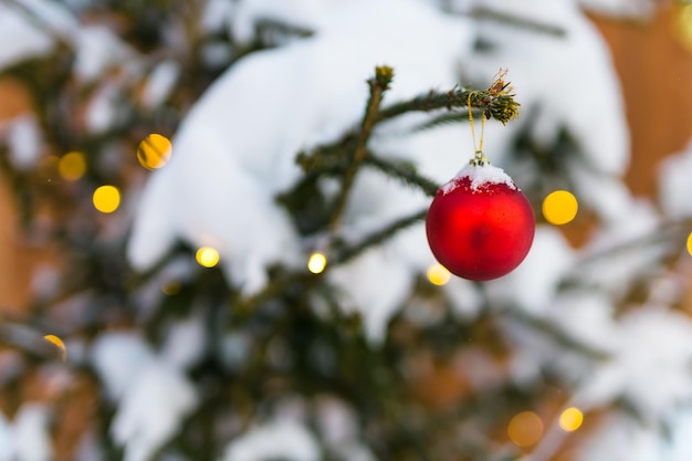 Weihnachtshintergrundkugeln und Zweig der Fichte mit Girlandenwinterferien und Feier kopieren Raum und leeren Platz für Text