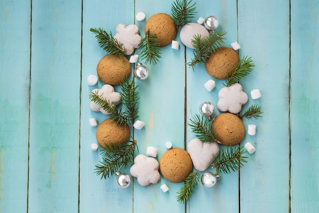 Weihnachtshölzerner Hintergrund mit Baumasten, Lebkuchen und Eibischen