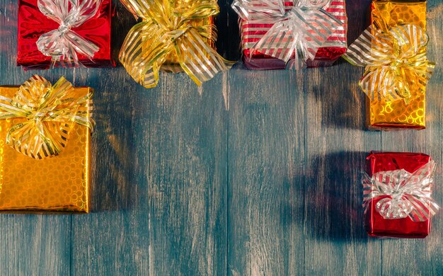 Weihnachtshölzerner Hintergrund mit Geschenken und einem Platz zum Kopieren.