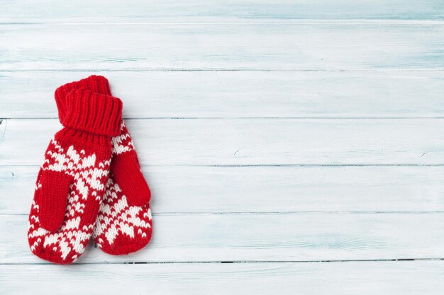 Weihnachtshölzerner Hintergrund mit Handschuhen