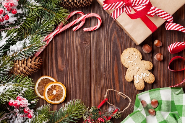 Weihnachtshölzerner Hintergrund mit Schneetannenbaum, Dekor und Geschenkbox